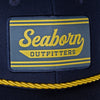 detail photo of front patch seaborn outfitters in yellow on navy background. yellow braided accent under patch above bill.